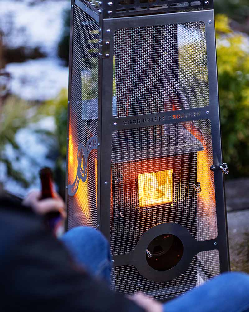 A dog sitting by the Lil' Timber Elite Patio Heater 